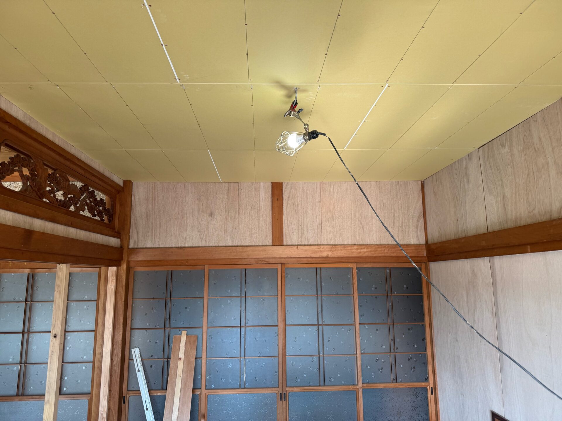 天井へ石膏ボードを貼り付ける作業