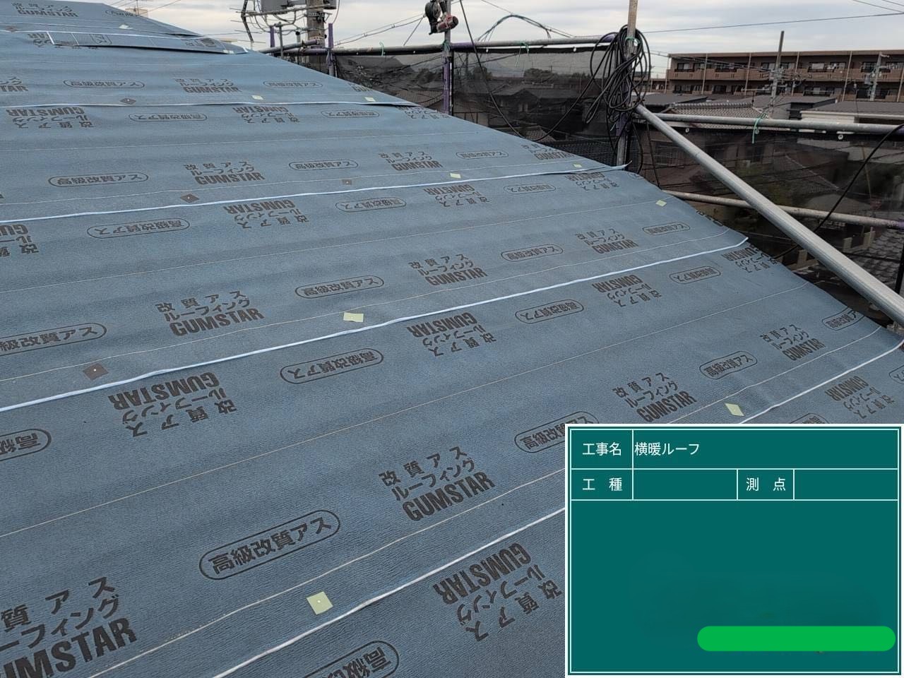 屋根全体に防水シートを敷き込む様子