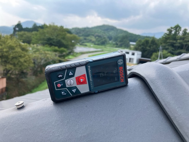 レーザー距離計で屋根を点検する様子