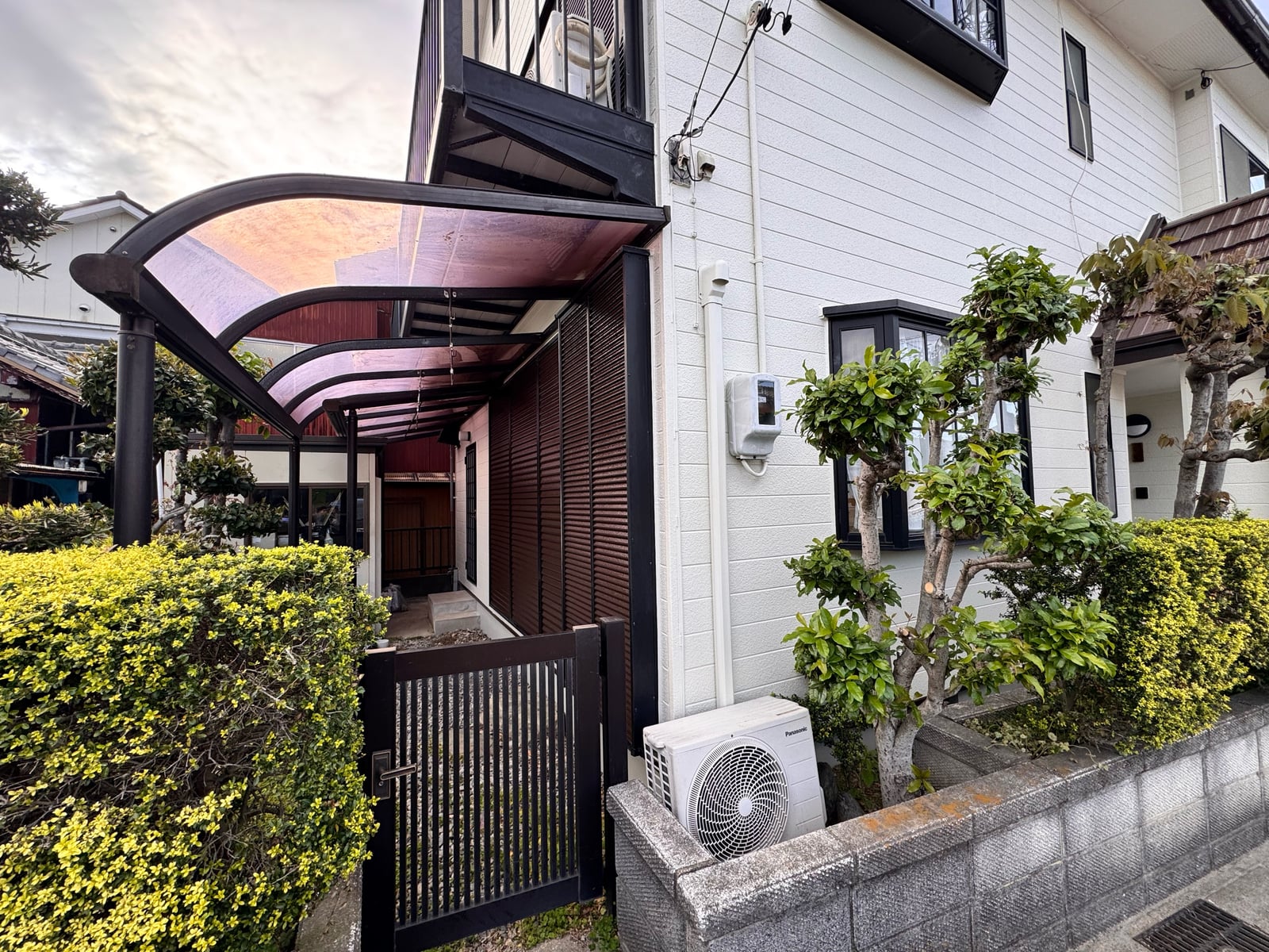 玄関アプローチ。テラス屋根の下から門周り、植栽、整えられた外壁まで、訪れる方を温かく迎える表情になりました。