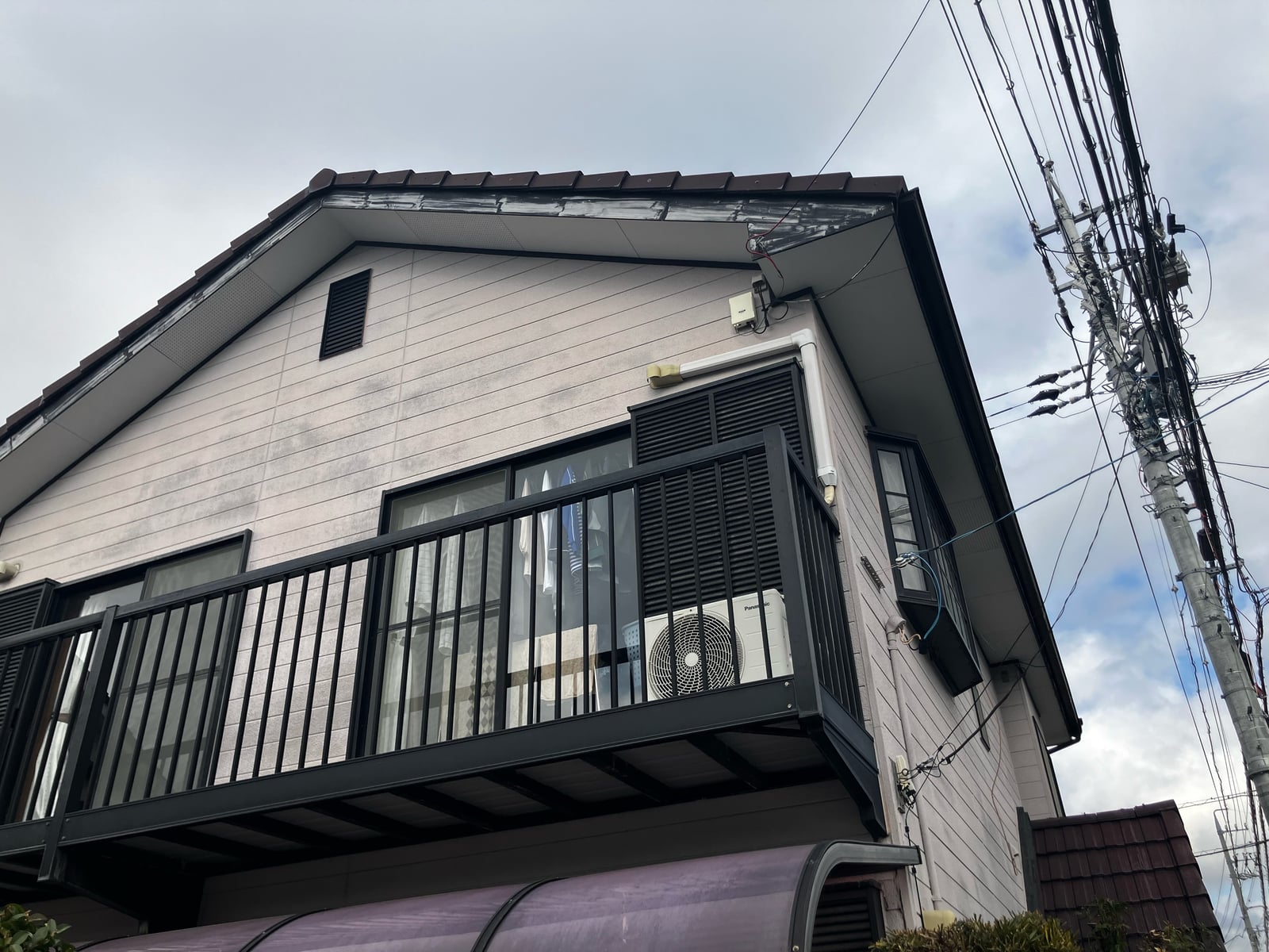 2階ベランダ周辺の外壁。色あせと汚れが目立ち、住まい全体のトーンを下げる要因になっていました。