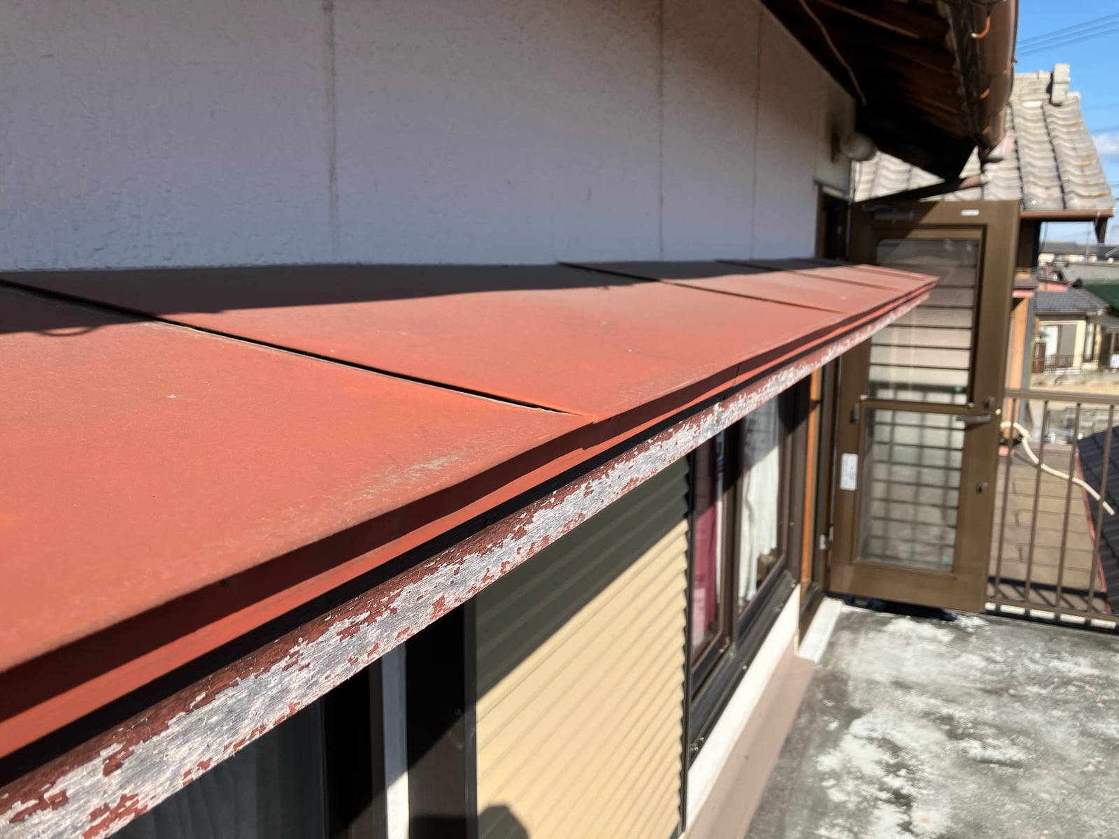 小庇の塗膜が剥離し、下地が見えている状態。早めの再塗装が必要でした。