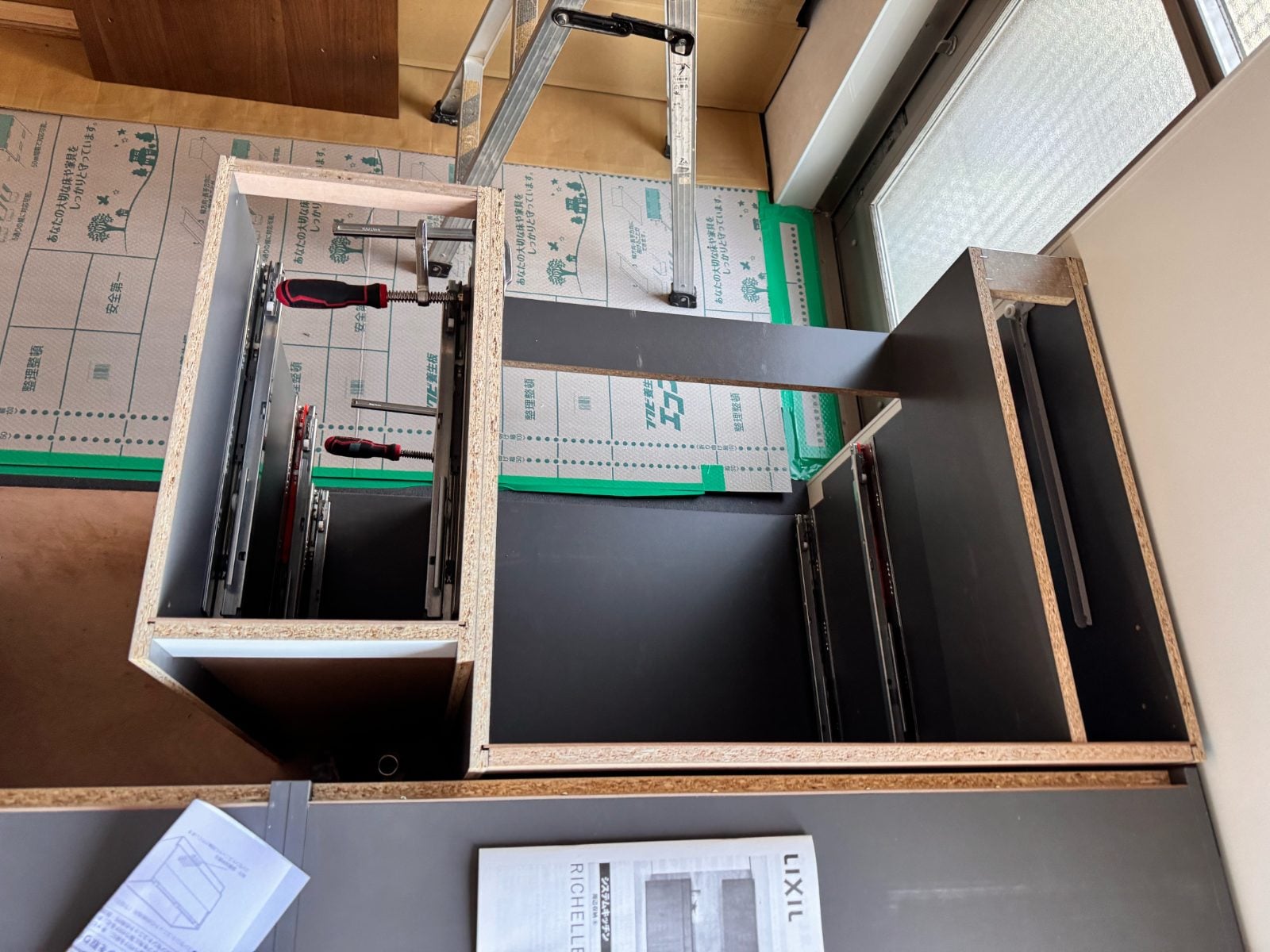 K様邸施工中のキャビネット引き出し組み立て。スライドレールをクランプで固定している作業工程です。