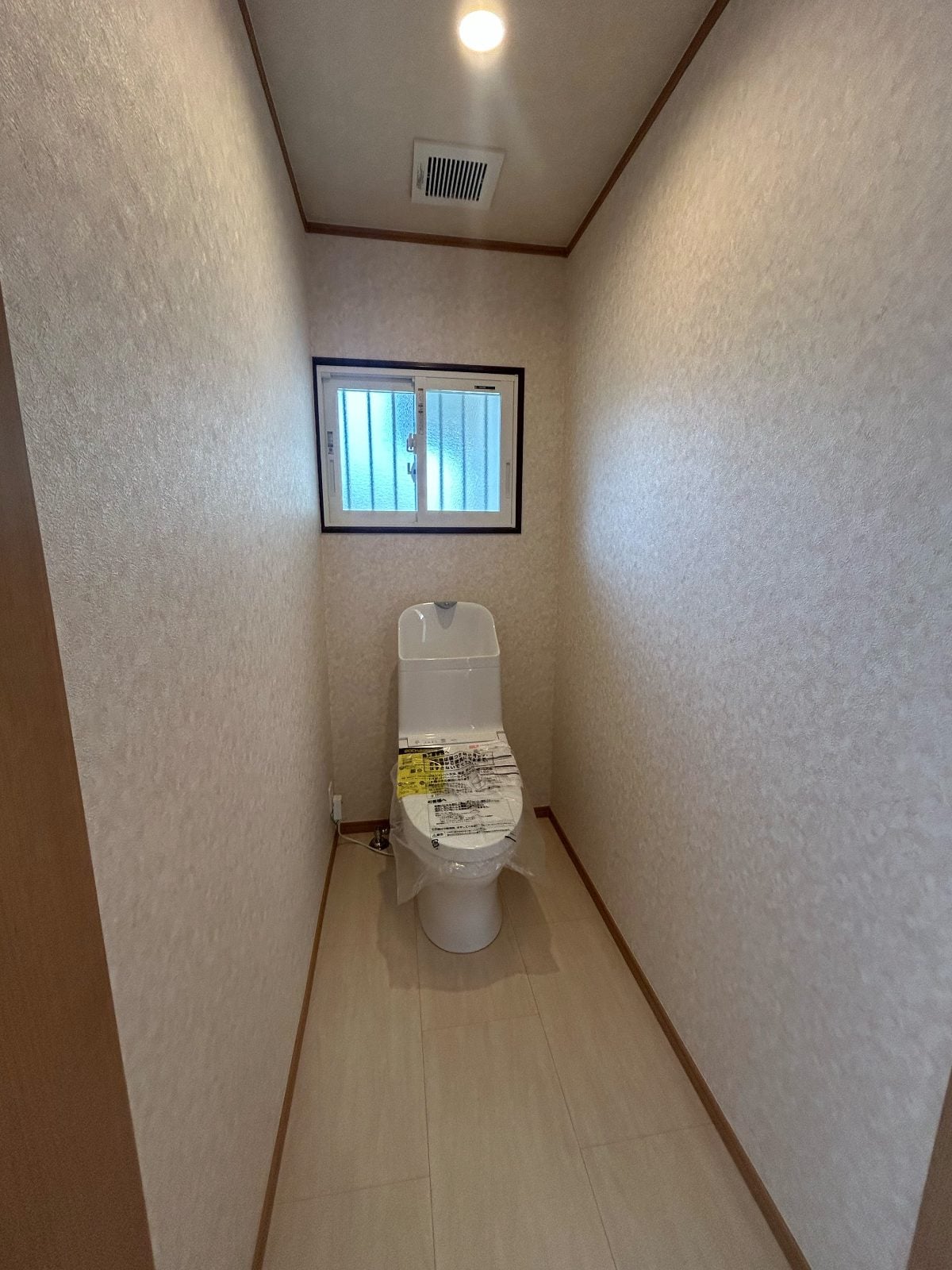M様邸トイレのリフォーム後全景。新設の洋式便器と張り替えたクロス・床で清潔感ある空間になりました。