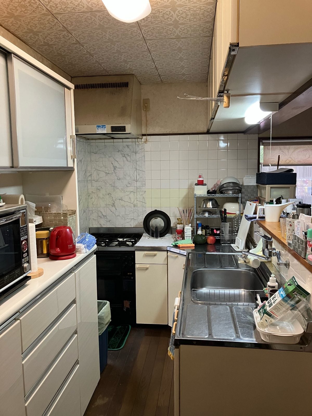 M様邸キッチンリフォーム前。既存シンク・コンロ・タイル壁・換気扇の全体状況を記録した施工前写真です。