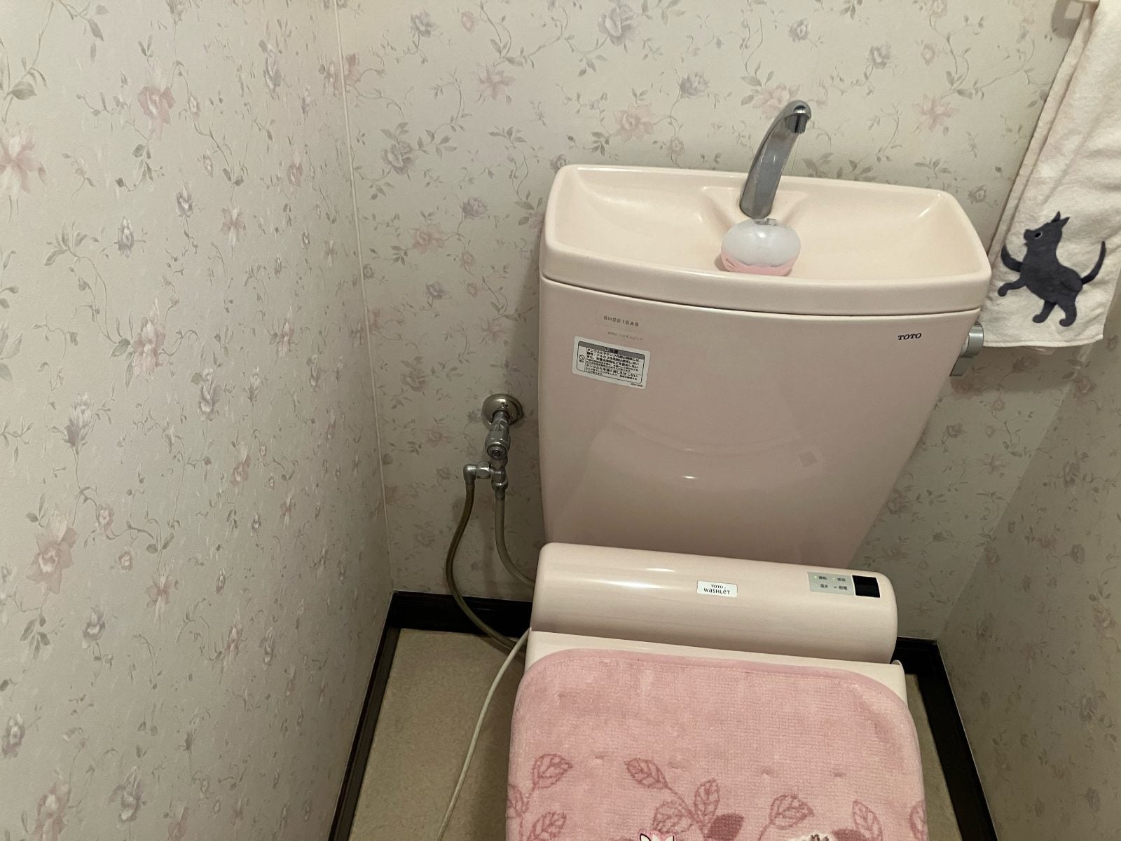 M様邸トイレリフォーム前。既存のTOTO製ピンク色便器・ウォシュレットと壁紙の状態を記録した施工前写真です。