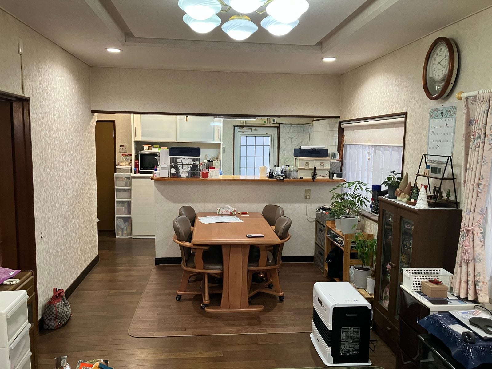 施工前のダイニングキッチン全景。対面カウンターと既存クロス・フローリングの状態を記録したM様邸の様子です。