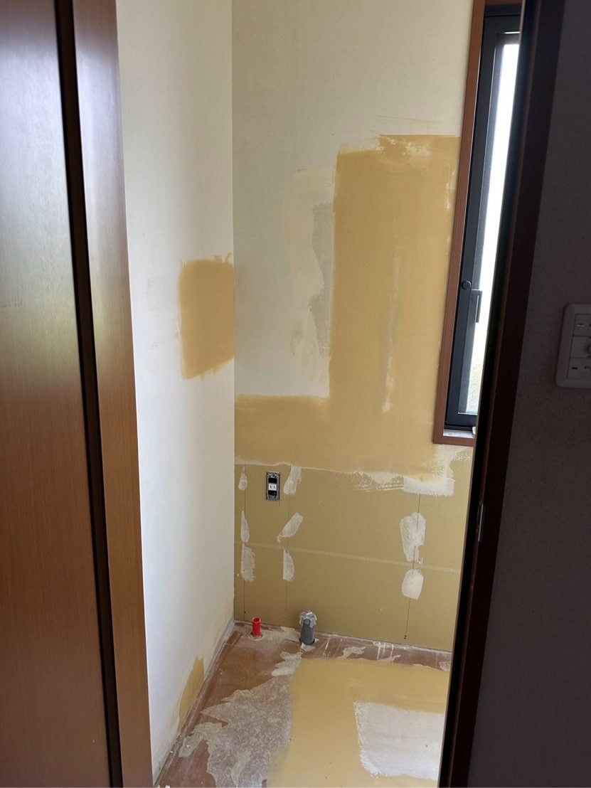 M様邸トイレ施工中、壁下地ボード張り替え作業中の様子。クロス撤去後の状態です。
