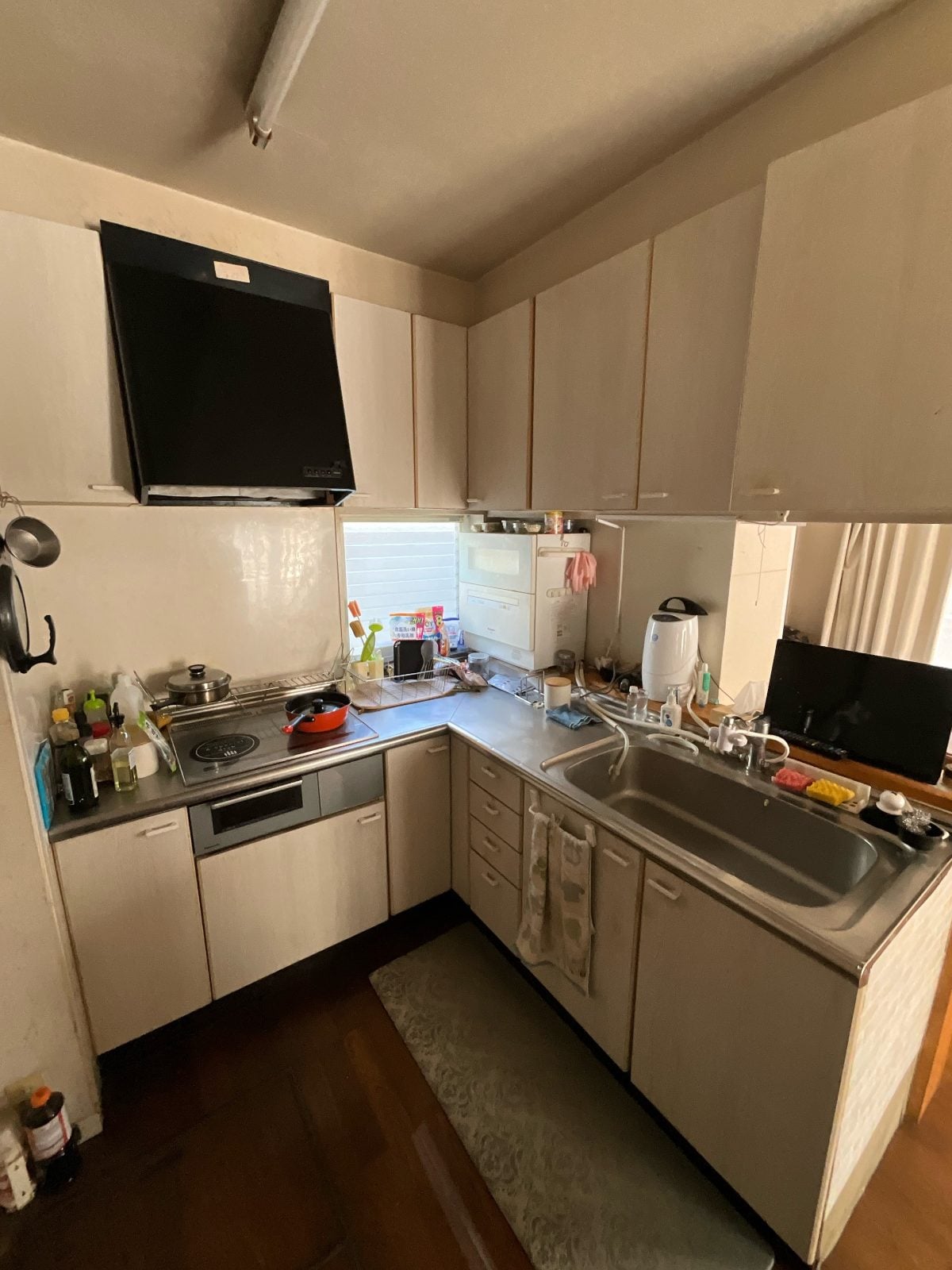 N様邸キッチンリフォーム前の様子。L型レイアウトの旧キッチン全体を記録した施工前写真です。