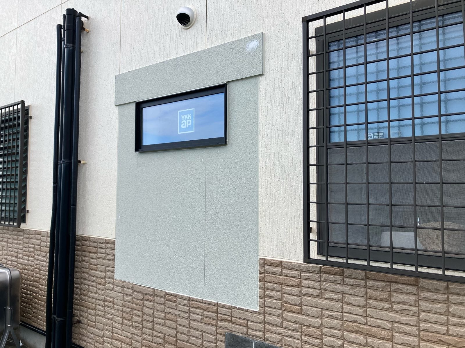 N様邸屋外壁面の浴室窓交換工事中。YKKap製新窓の取付直後の外観です。