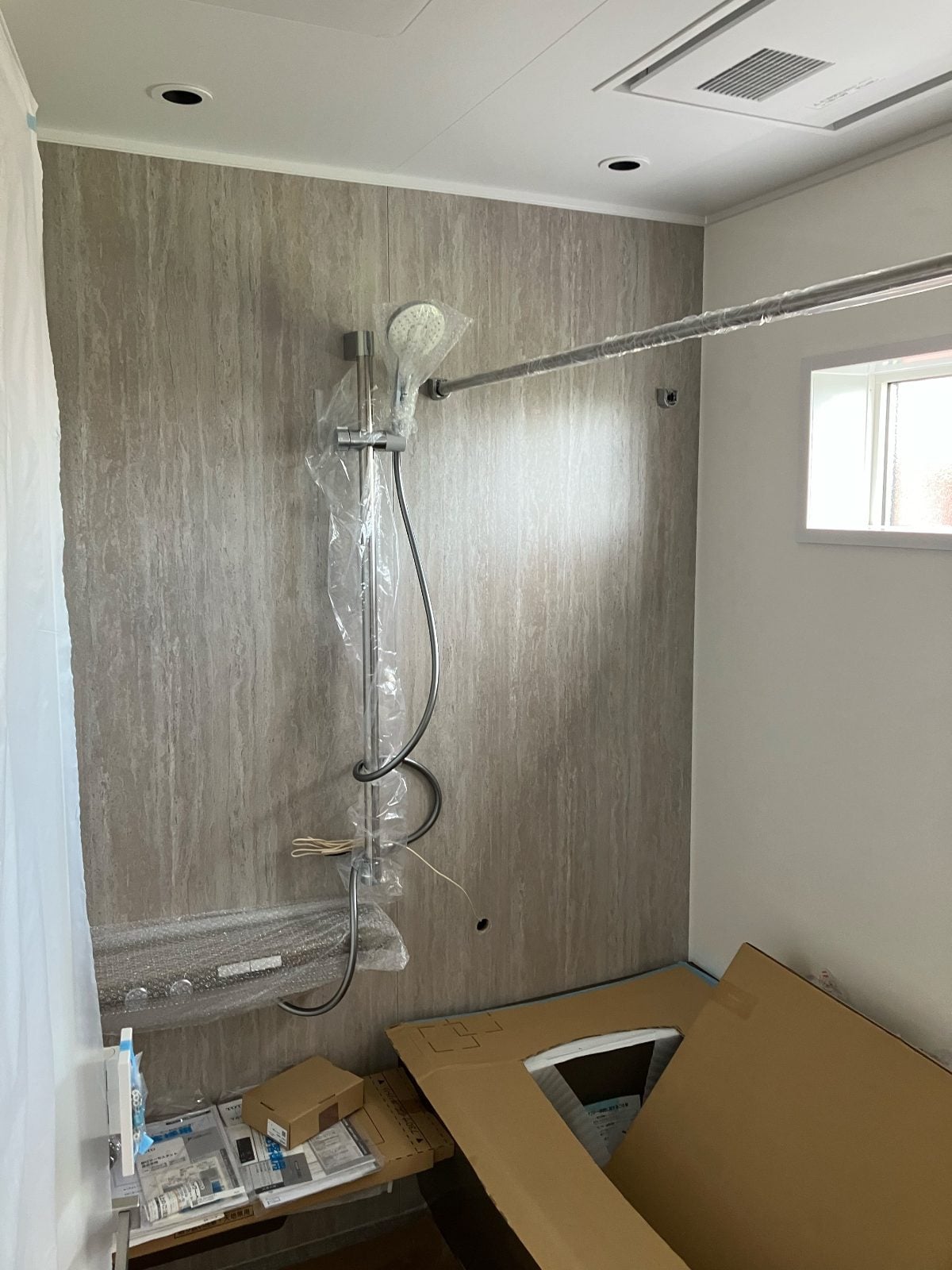 N様邸浴室ユニットバス組立中。壁パネルとシャワー設備の設置が進んでいます。