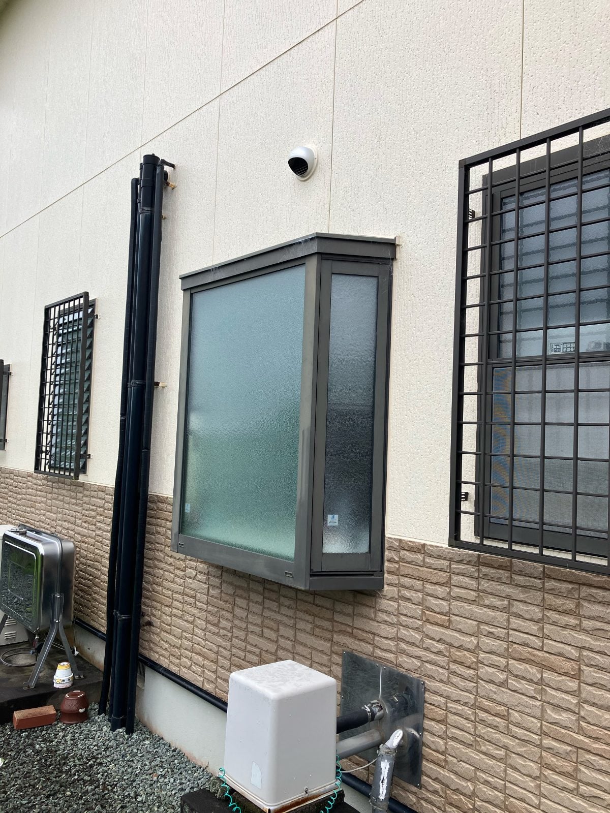 N様邸施工前の屋外壁面。浴室窓まわりの既存設備・配管の状況です。
