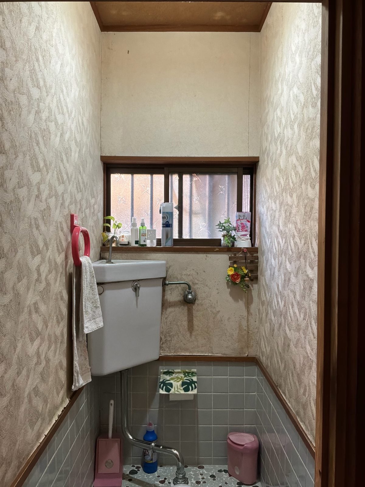 I様邸トイレ施工前の全体。老朽化した壁クロスや和式便器タンク周りの劣化が確認できます。