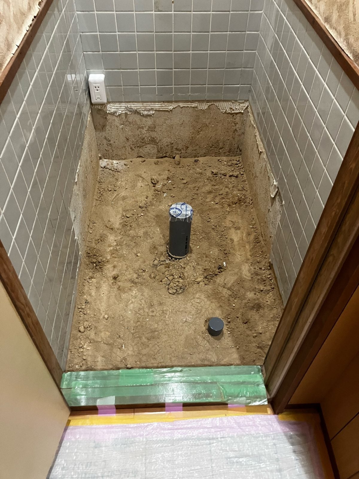 I様邸トイレ解体工事中。和式便器と床タイルを撤去し、排水管を露出した状態です。