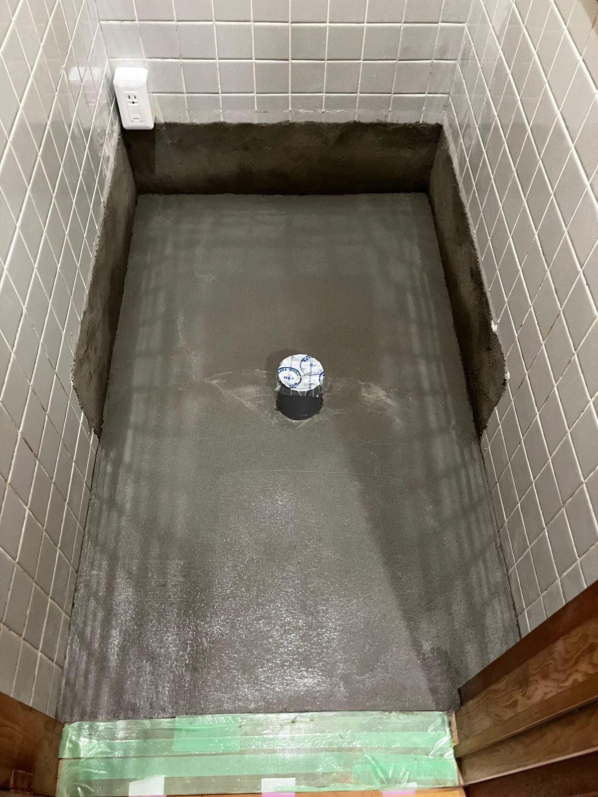 I様邸トイレ床下地にモルタルを流し込み平滑に均した施工中の様子です。