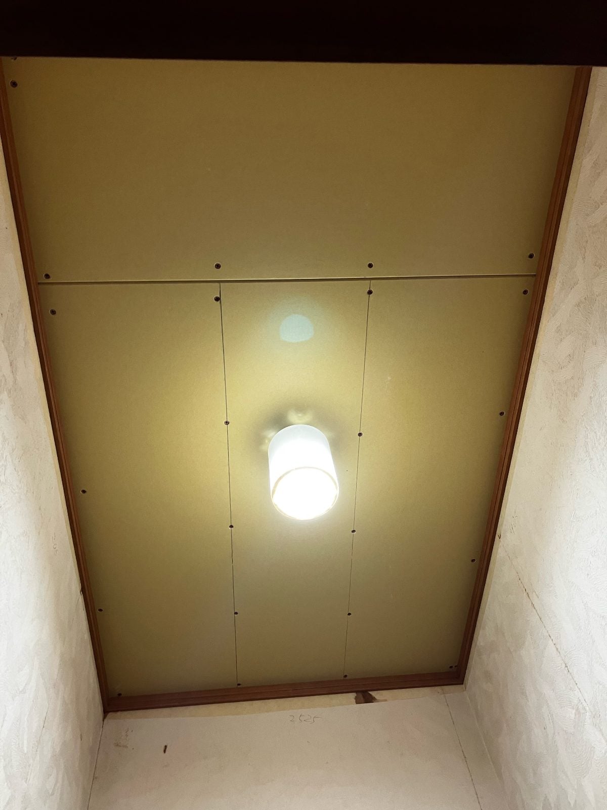 I様邸トイレ施工中の天井。既存の化粧板と照明器具の状態を記録した写真です。